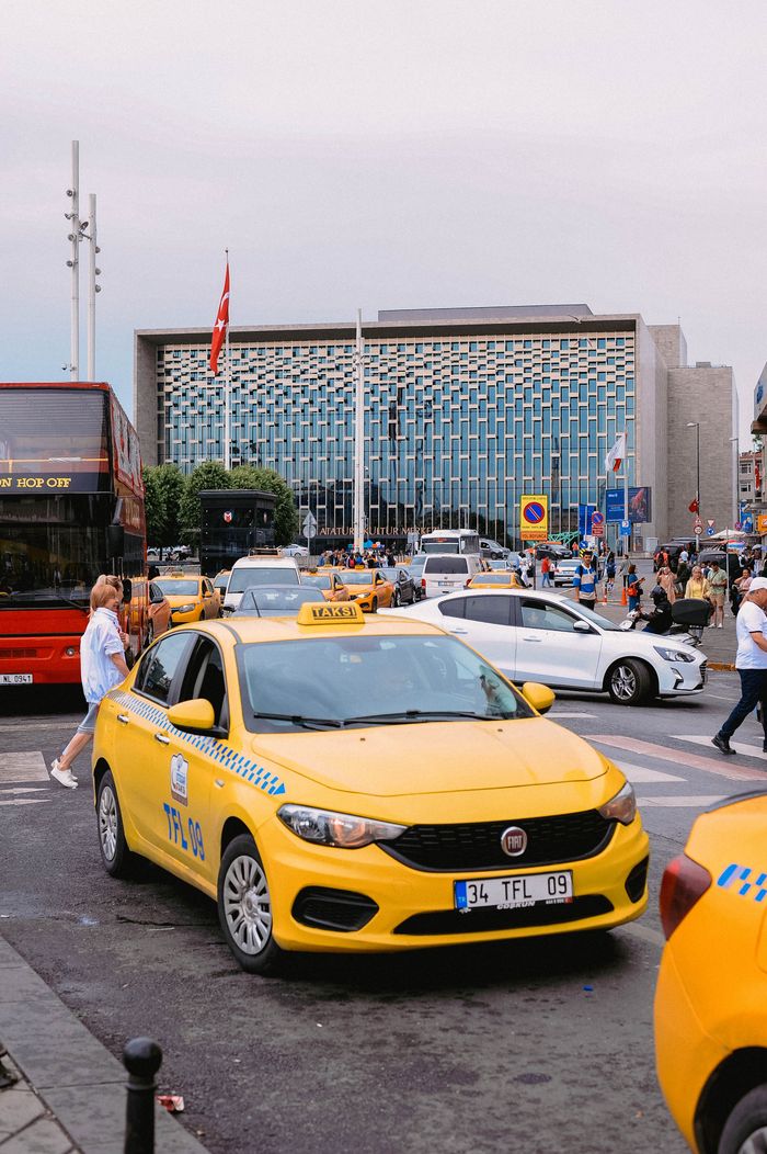 About Yellow taxis and bustling street scene in front of a modern building in Istanbul, Turkey.