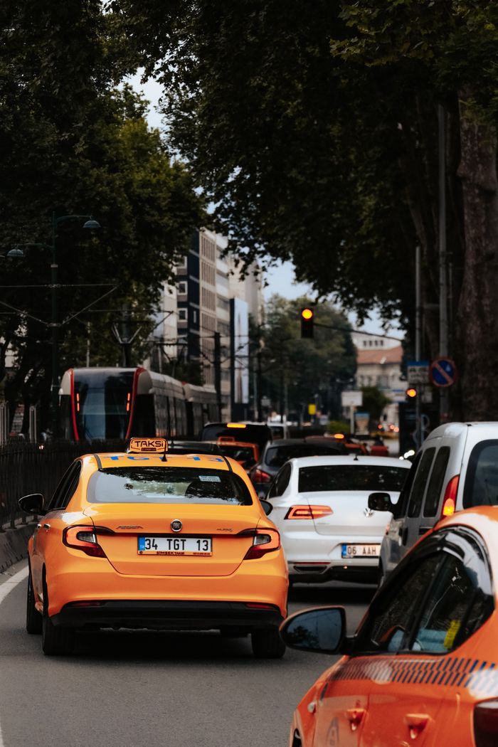 The Art of Drawing Readers In: Your attractive post title goes here A bustling street scene featuring a yellow taxi amid city traffic under large trees.