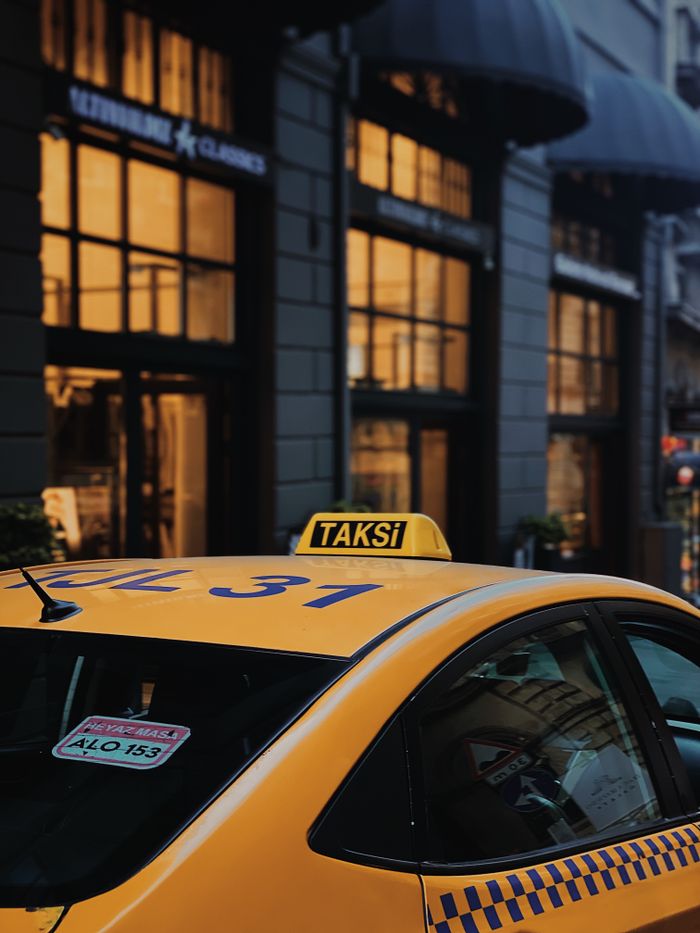 Services A yellow taxi parked on a lively street in Istanbul, capturing urban atmosphere.