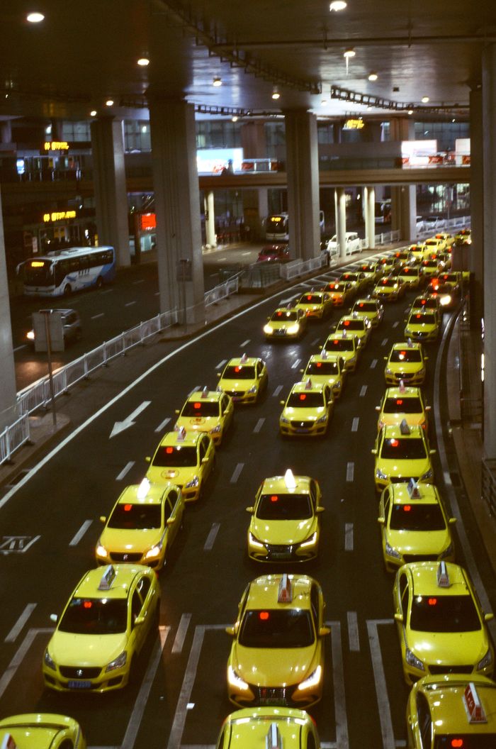Services Aerial view of yellow taxis in an urban setting, showcasing a busy city traffic jam at night.