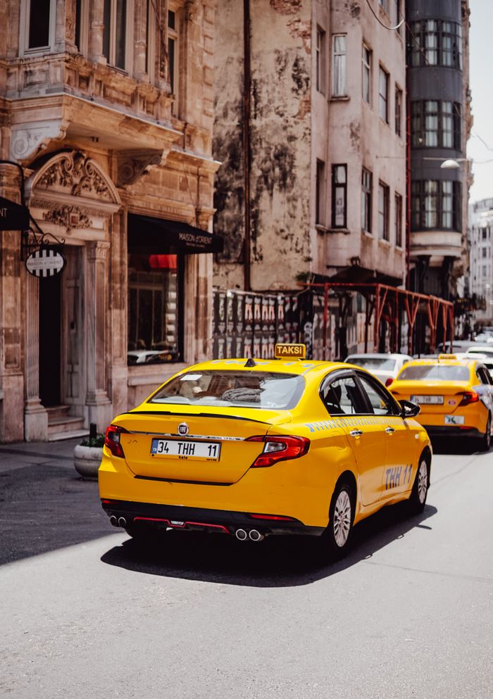 Mastering the First Impression: Your intriguing post title goes here Yellow taxis navigate the charming streets of İstanbul with historic architecture in the backdrop.