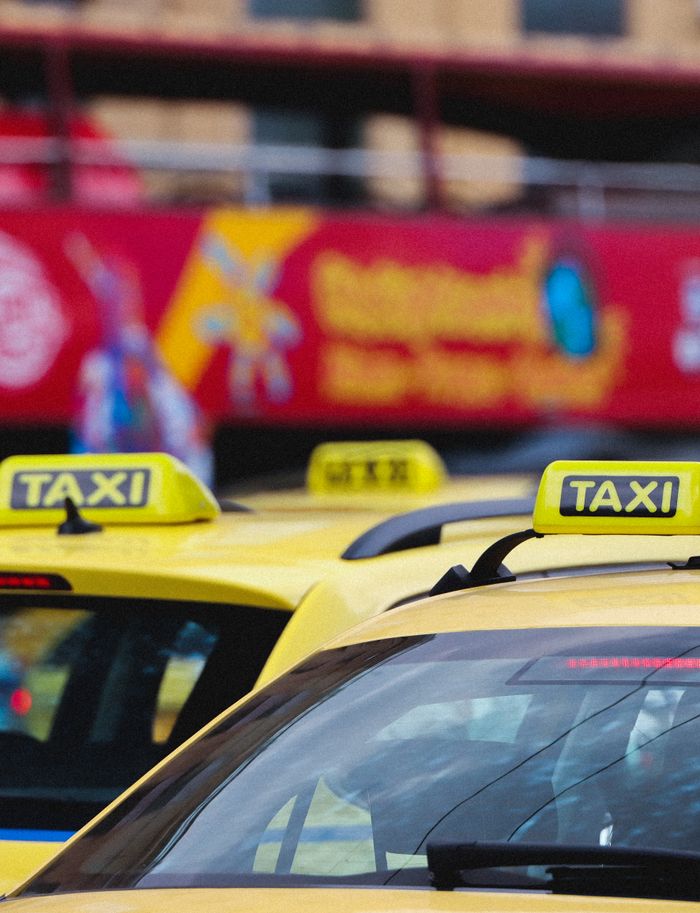 Home Yellow taxis lined up on a street in Athens, Greece, showcasing urban transportation.